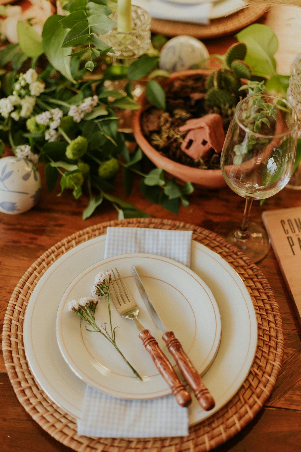 Rustikales Tischarrangement mit Blumen und Topfpflanze.