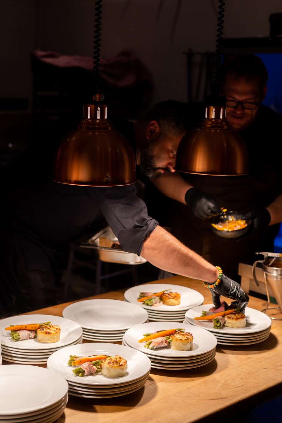 Zwei Köche richten sorgfältig Gourmetgerichte in einer professionellen Küche an.